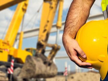 A man holding onto a yellow hard hat