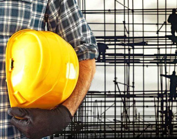 A man holding a yellow hard hat in his hands.