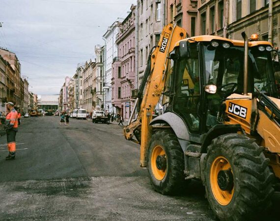 A yellow and black tractor parked on the side of a road.