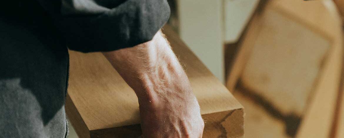 A person holding onto some wood in their hand.