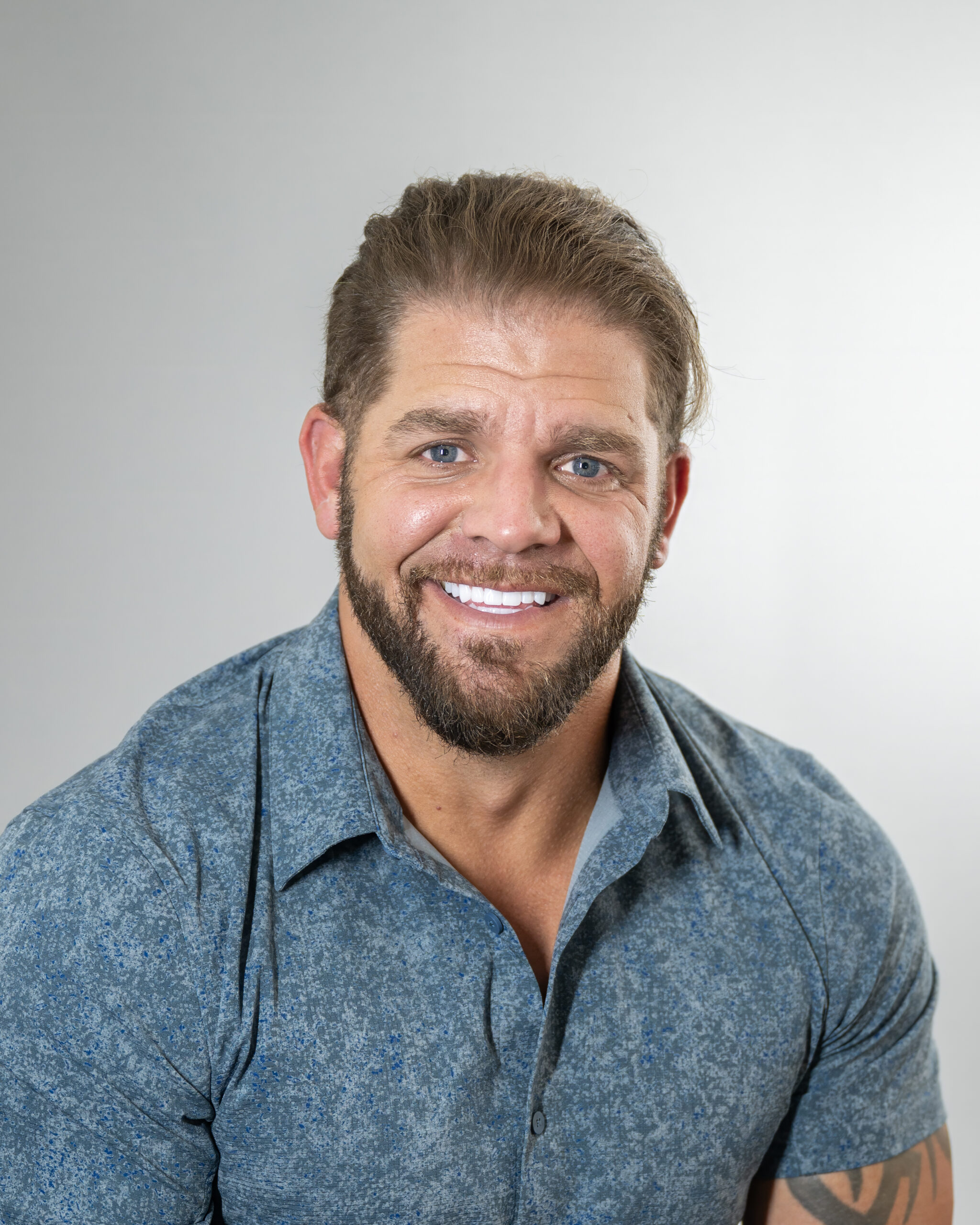 Smiling man in blue shirt portrait.