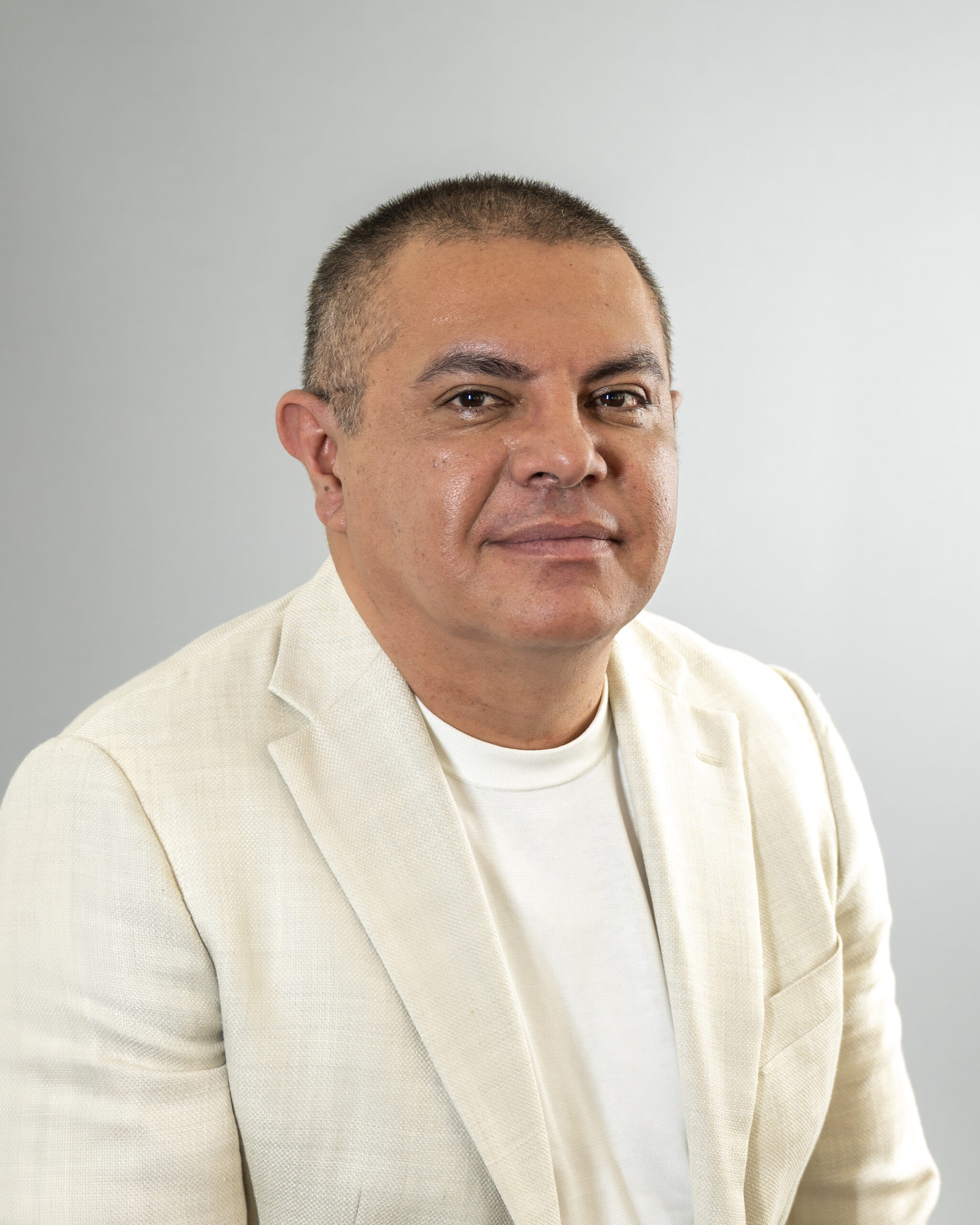 Portrait of a man in a beige blazer.