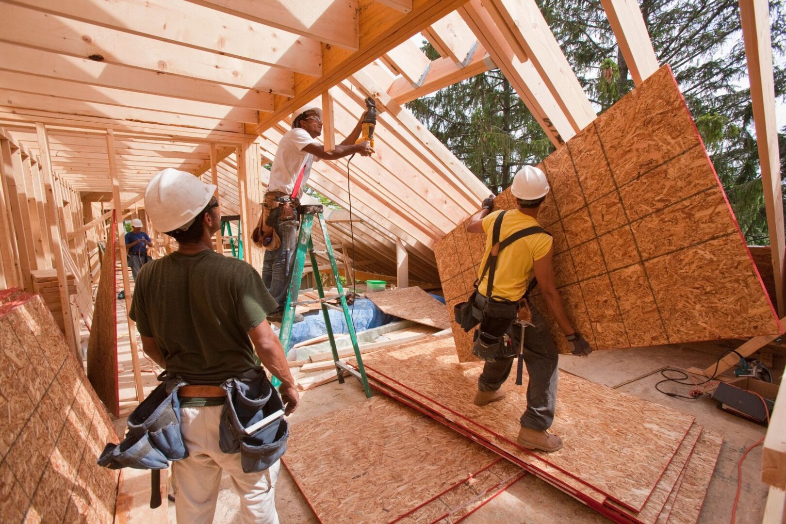 Construction workers installing OSB sheeting.